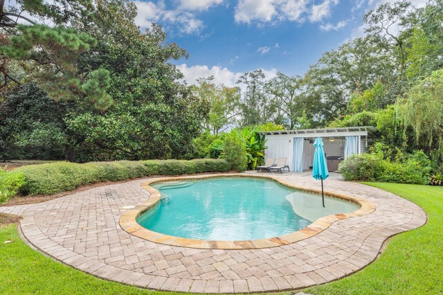 view of pool with a yard, an outbuilding, and a patio area