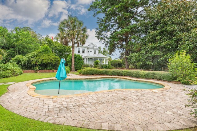 view of pool featuring a lawn and a patio area