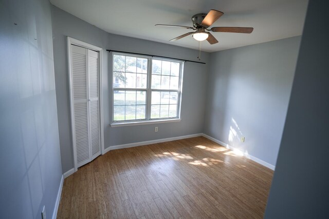 empty room with ceiling fan and hardwood / wood-style floors