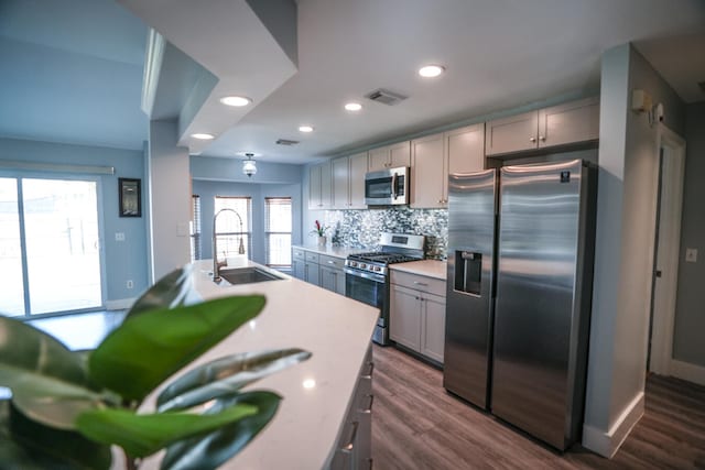 kitchen with dark hardwood / wood-style floors, gray cabinets, appliances with stainless steel finishes, and a wealth of natural light