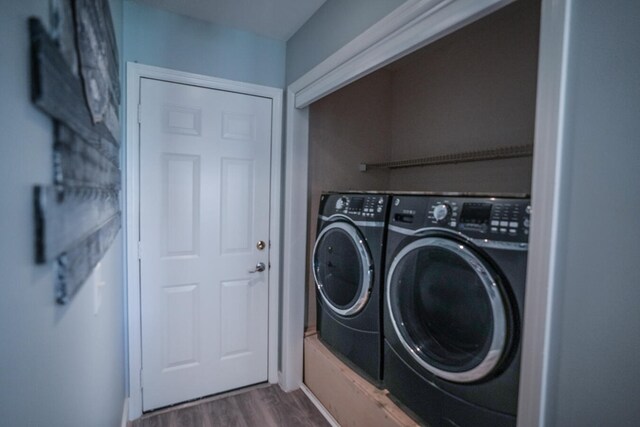 laundry area with washer and dryer and dark hardwood / wood-style flooring