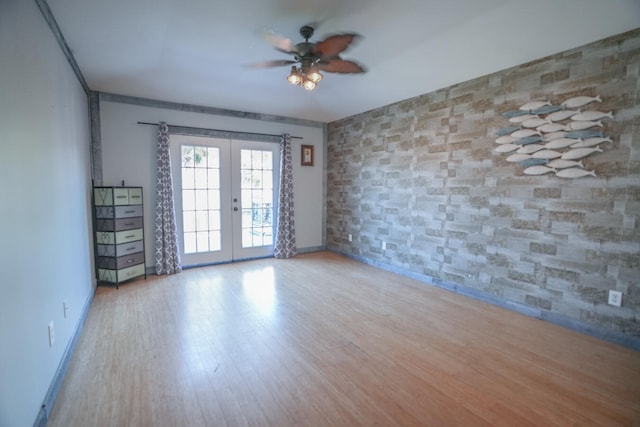 empty room with french doors, light hardwood / wood-style floors, and ceiling fan