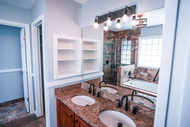 bathroom featuring plus walk in shower, an inviting chandelier, and vanity