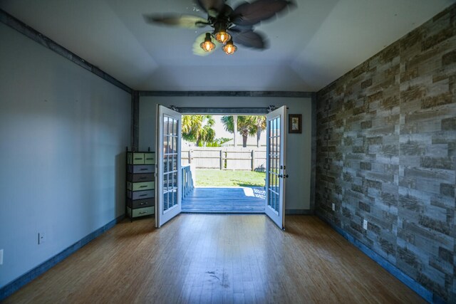 entryway with ceiling fan, hardwood / wood-style flooring, and vaulted ceiling