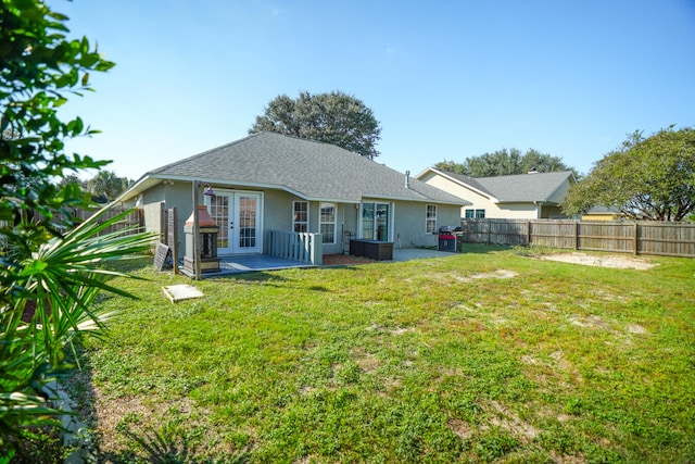 back of property with french doors, a yard, and a patio