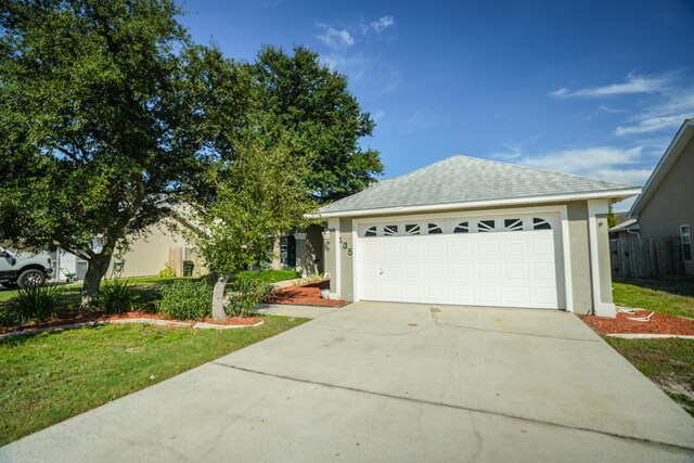 view of front of property with a garage and a front lawn