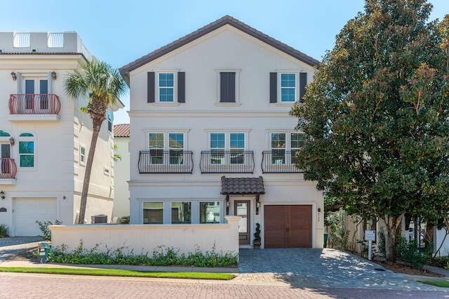 4795 Ocean Blvd, Destin, FL 32541 - view of front of house featuring a garage, decorative driveway, stucco siding, and a balcony