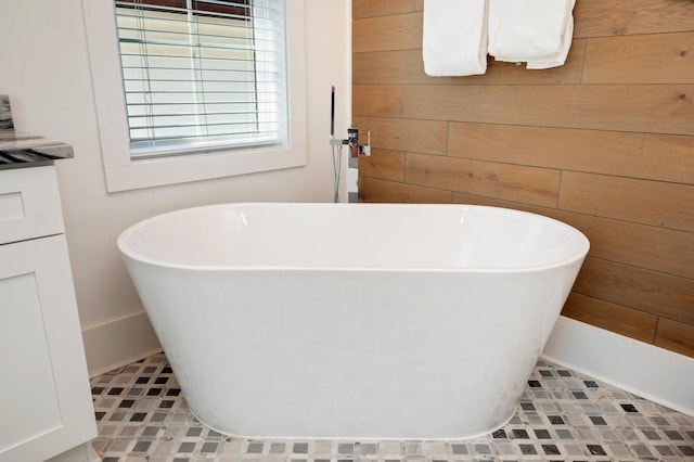 bathroom featuring tile patterned floors, a bathing tub, and wooden walls