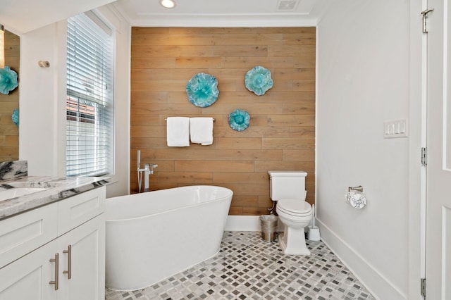 bathroom featuring vanity, tile patterned floors, wooden walls, toilet, and a tub