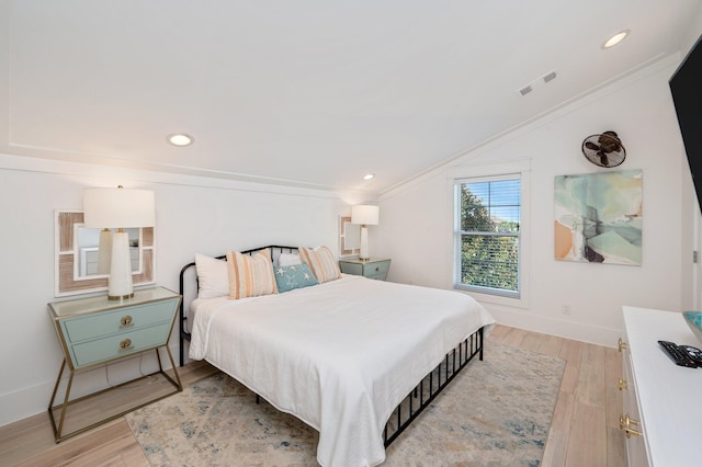 bedroom with crown molding and light hardwood / wood-style floors