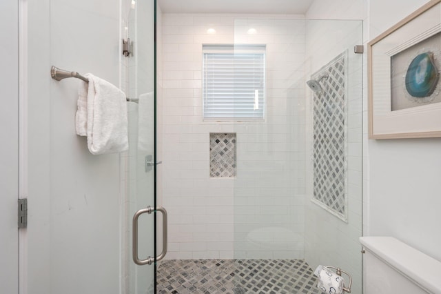 bathroom featuring toilet and an enclosed shower