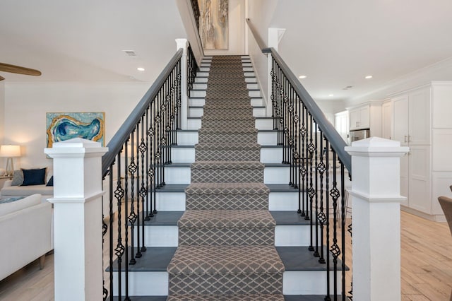 stairs featuring hardwood / wood-style flooring and ornamental molding