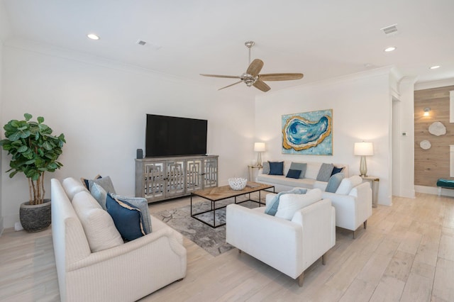 living room featuring ceiling fan, light hardwood / wood-style floors, and crown molding