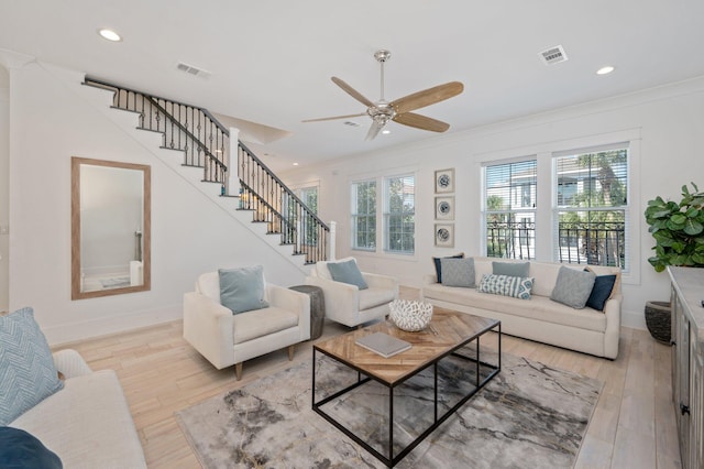 living room featuring light hardwood / wood-style floors, ceiling fan, and crown molding