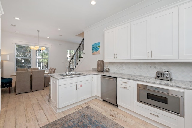 kitchen featuring white cabinets, sink, light wood-type flooring, kitchen peninsula, and stainless steel appliances