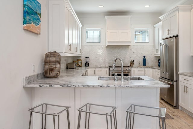 kitchen with a breakfast bar area, a wealth of natural light, and high end refrigerator