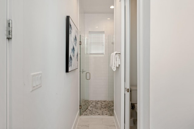 bathroom featuring an enclosed shower and toilet