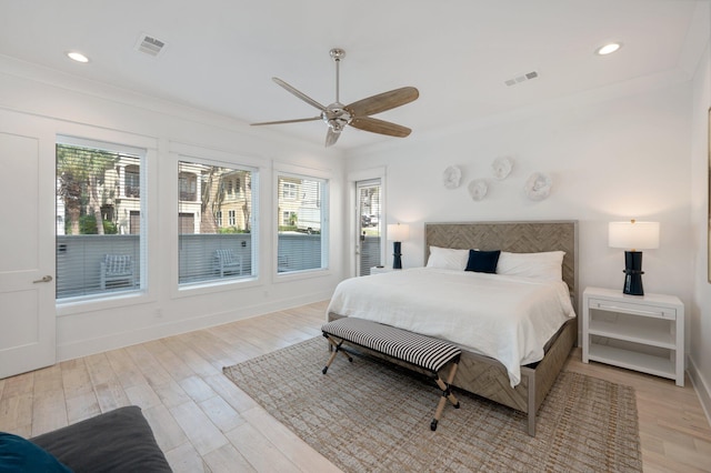 bedroom featuring multiple windows, ceiling fan, and light wood-type flooring