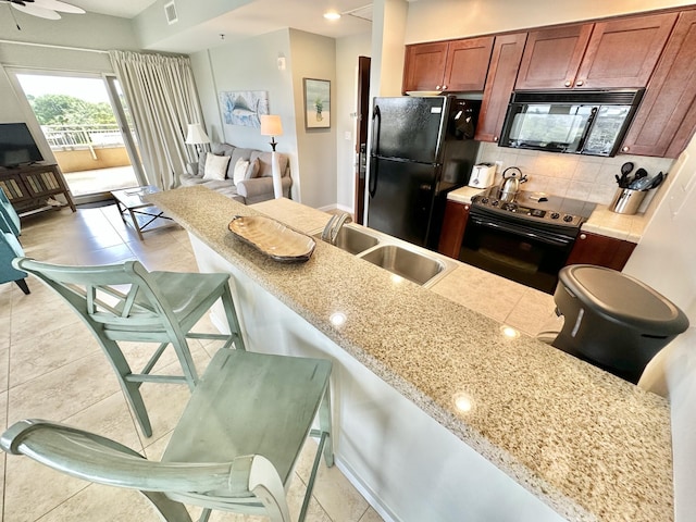 5002 S Sandestin Blvd # 6322, Miramar Beach, FL 32550 - kitchen with black appliances, tasteful backsplash, light tile patterned floors, and a kitchen breakfast bar