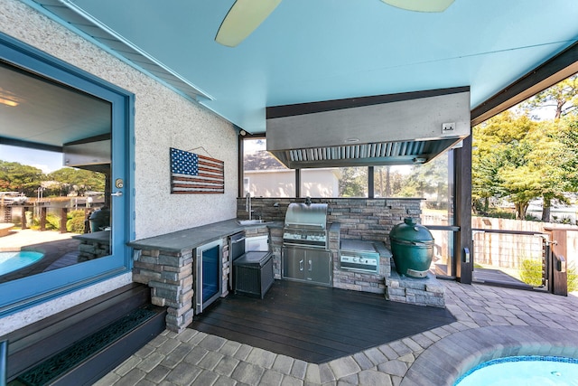 wooden deck featuring grilling area, area for grilling, sink, and ceiling fan