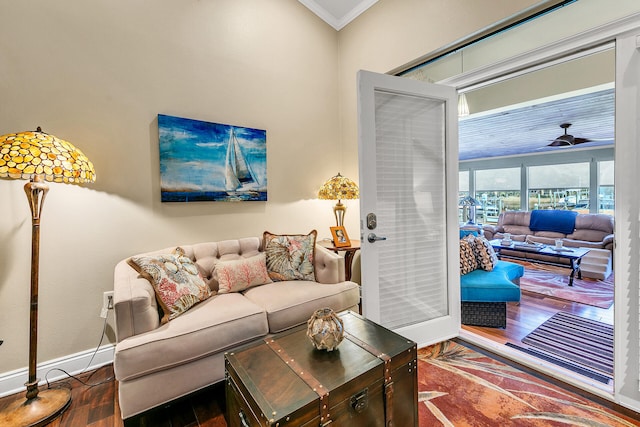 living room featuring ornamental molding, ceiling fan, and dark wood-type flooring