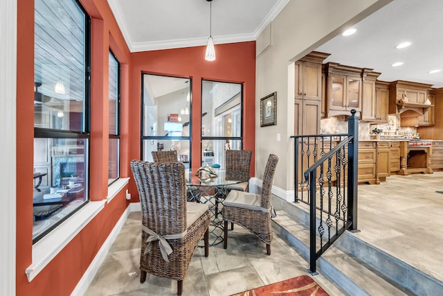 dining space with vaulted ceiling, a healthy amount of sunlight, and crown molding