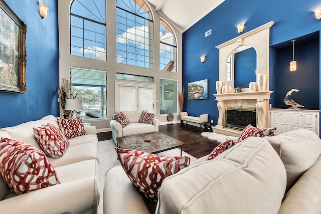 living room featuring wood-type flooring, a high end fireplace, and high vaulted ceiling