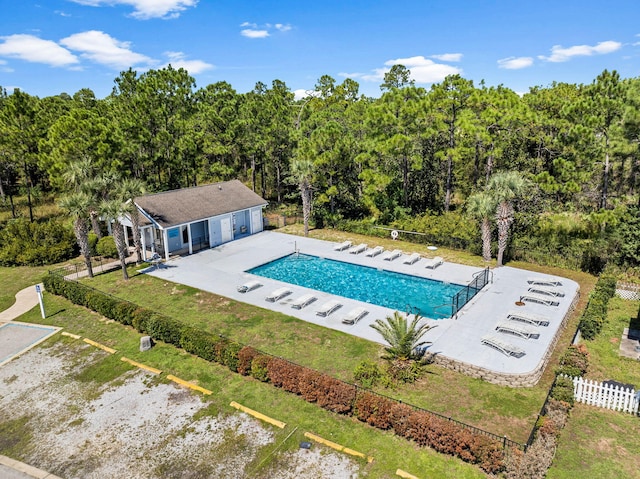 view of swimming pool featuring a yard, an outbuilding, and a patio area