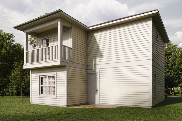 rear view of house featuring a balcony and a lawn