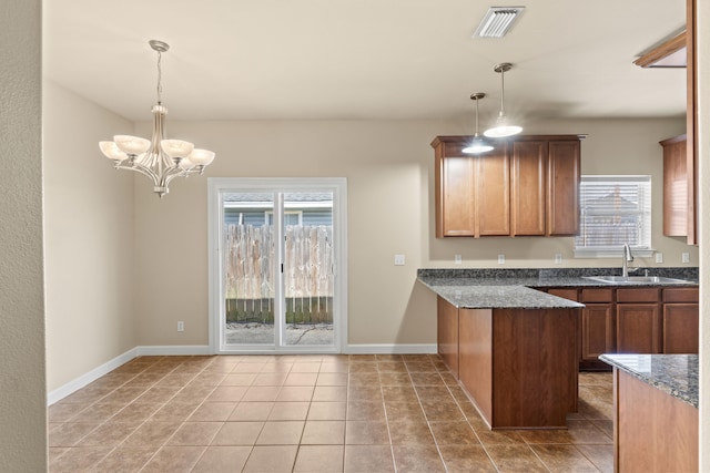 kitchen featuring light tile patterned flooring, sink, a chandelier, and decorative light fixtures