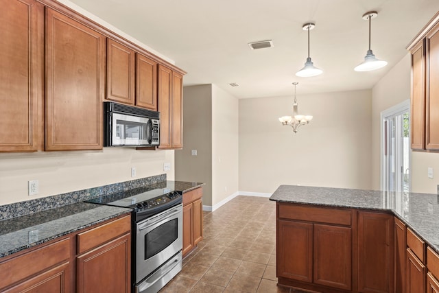 kitchen featuring an inviting chandelier, stainless steel appliances, decorative light fixtures, and dark stone counters