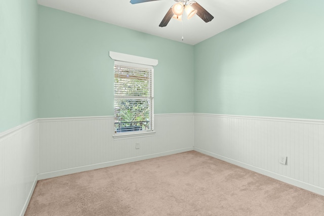 spare room with ceiling fan and light colored carpet