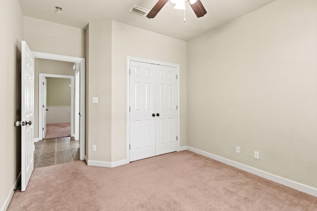 unfurnished bedroom with light carpet, a closet, and ceiling fan