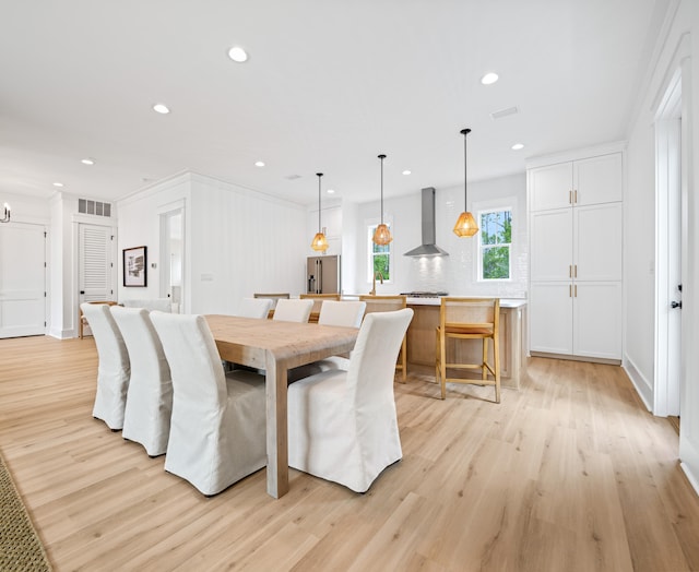 dining space featuring light hardwood / wood-style flooring and crown molding