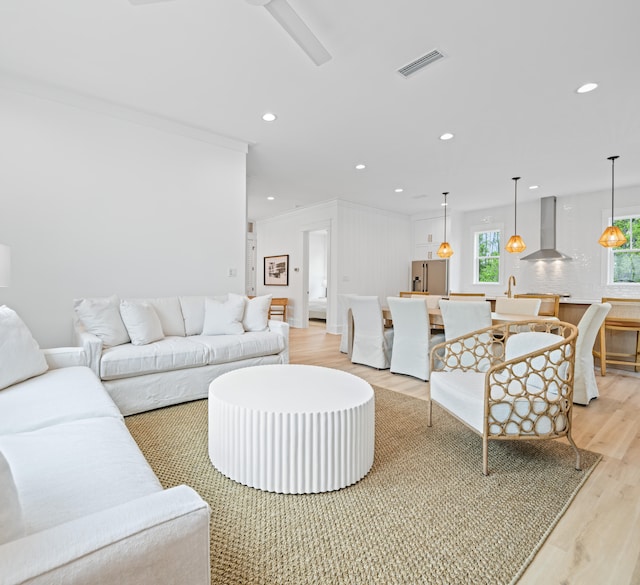 living room featuring light hardwood / wood-style floors and crown molding