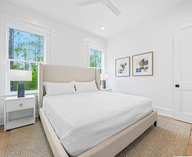 bedroom featuring wood-type flooring, ornamental molding, and ceiling fan