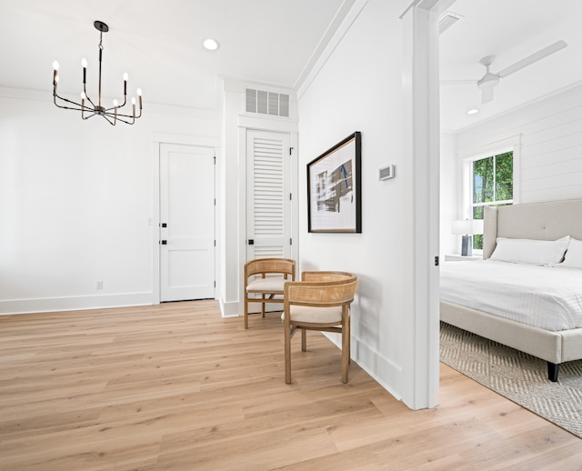 interior space featuring ceiling fan with notable chandelier, light hardwood / wood-style floors, and ornamental molding