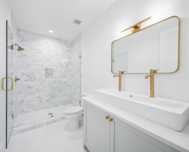 bathroom with vanity, tile patterned flooring, toilet, and a shower with door