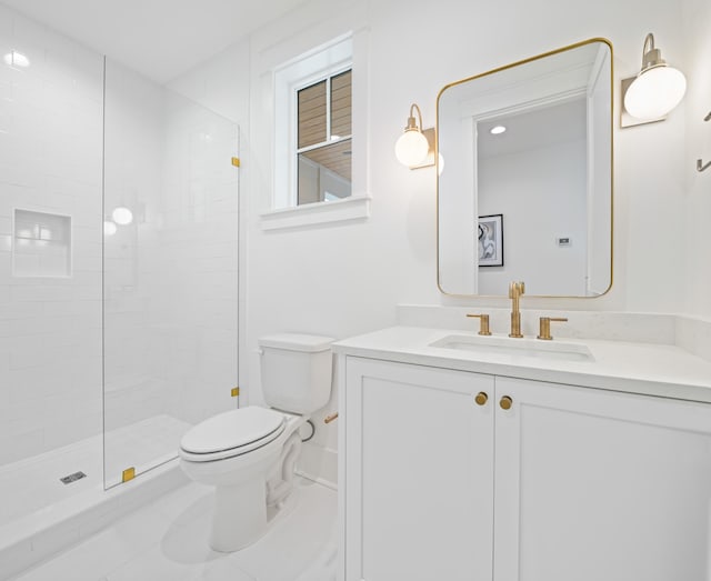 bathroom featuring tiled shower, vanity, and toilet