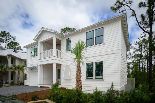 view of front of property featuring a balcony and a garage