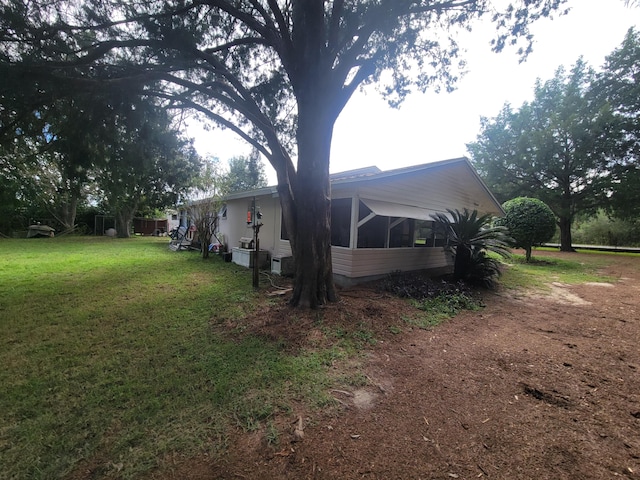 view of side of property with a sunroom and a yard