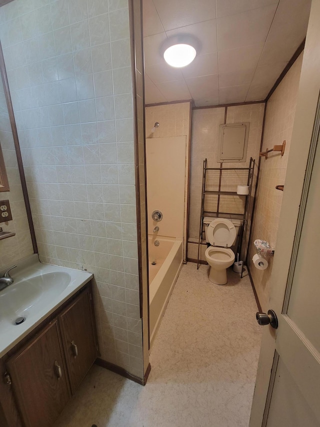 full bathroom with vanity, toilet, shower / washtub combination, and tile walls