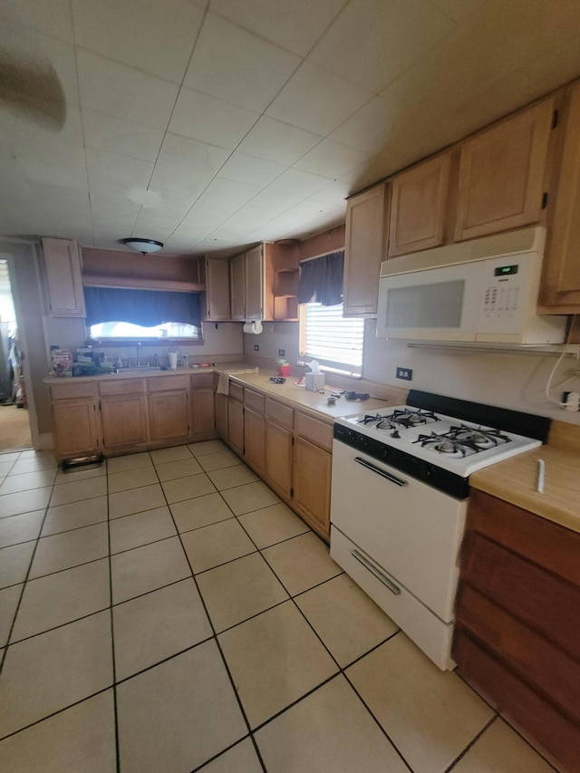 kitchen featuring light tile patterned floors and white appliances