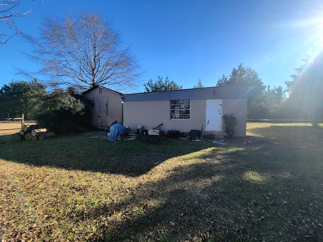 view of front of house featuring a front lawn and a storage unit