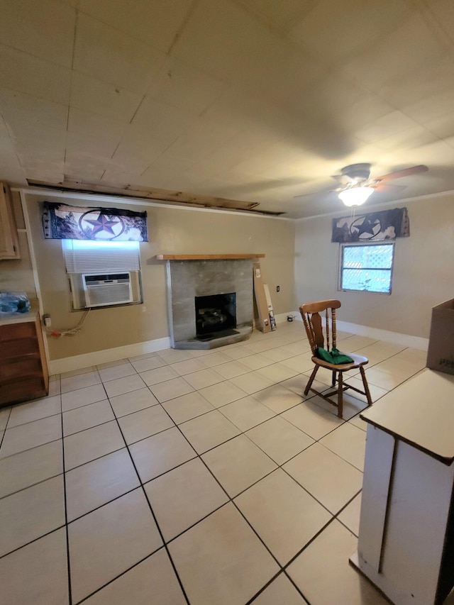 unfurnished living room with cooling unit, ceiling fan, light tile patterned flooring, and a tile fireplace