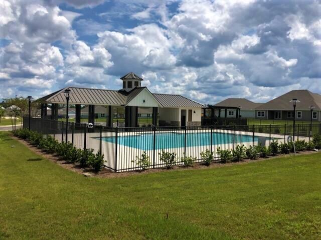 pool with fence, a lawn, and a gazebo