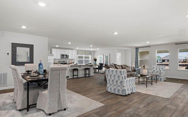 living room with dark wood-style floors, plenty of natural light, baseboards, and recessed lighting