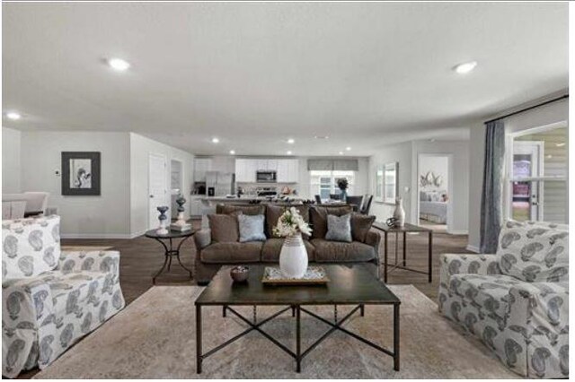 living area with light wood-type flooring, baseboards, and recessed lighting