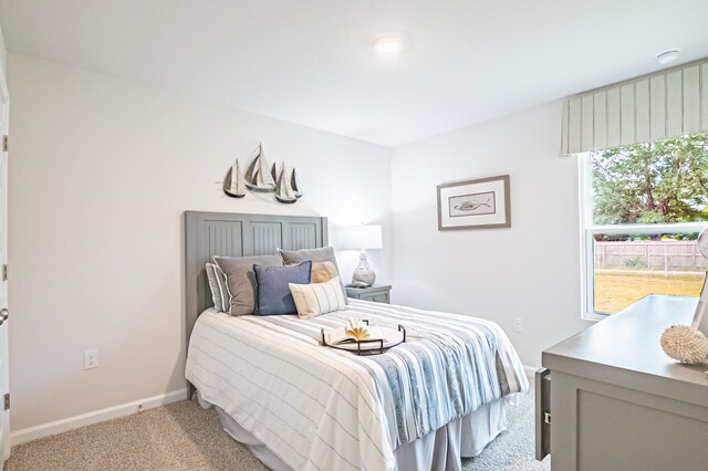 bedroom with light carpet and baseboards