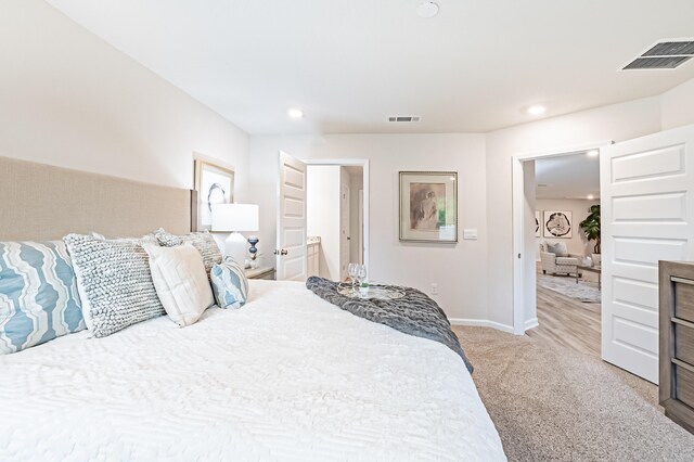 bedroom featuring baseboards, recessed lighting, visible vents, and light colored carpet